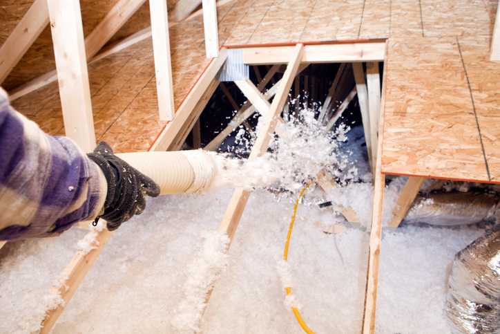 picture of a man holding an attic insulation vacuum